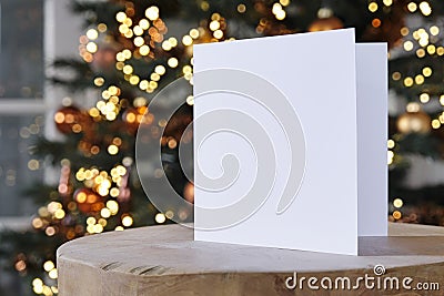 Standing empty square greeting card mock up in front of a christmas tree Stock Photo