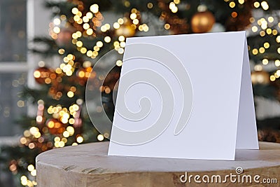 Standing empty square greeting card mock up in front of a christmas tree Stock Photo