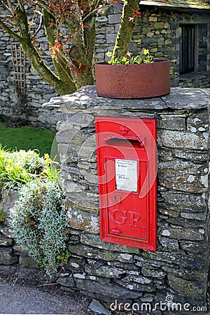 Keswick, Cumbria, UK - April 6th 2019: Old vintage British Georgian letter box, mounted into a dry stone wall in the English Lake Editorial Stock Photo