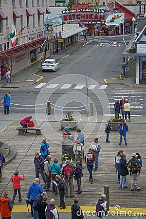 Ketchikan, Alaska: Tour guides holding signs greet cruise ship passengers Editorial Stock Photo