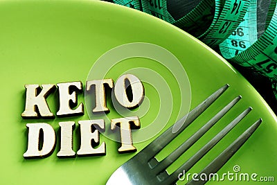 Keto diet on a green plate and measuring tape Stock Photo