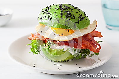 Keto paleo diet avocado breakfast burger with bacon, egg, tomato Stock Photo