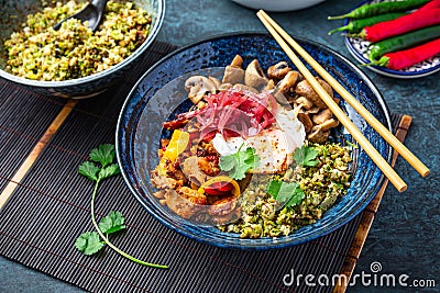 Ketogenic diet bowl with organic cauliflower and broccoli rice, stir fried chicken, mushrooms, egg and onions Stock Photo