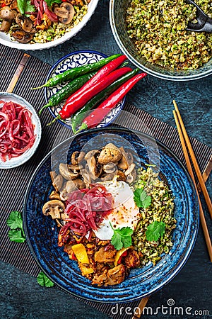 Ketogenic diet bowl with organic cauliflower and broccoli rice, stir fried chicken, mushrooms, egg and onions Stock Photo