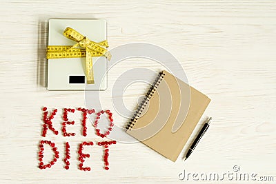 Ketogenic diet notes in the notebook on natural wood table. Concept of Ketogenic diet with scale and messure tape Stock Photo