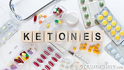 KETONES medicine word on wooden blocks on a desk. Medical concept with pills, vitamins, stethoscope and syringe on the background Stock Photo