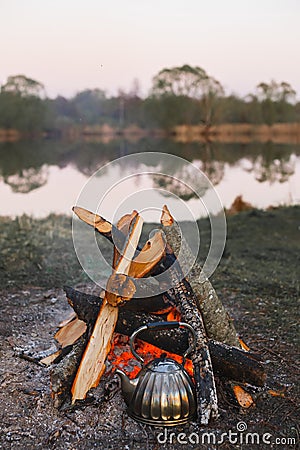 Kettle stands by the fire on the lake Stock Photo