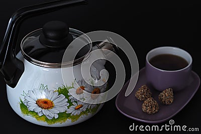 Beautiful enamelled kettle with a whistle on a black background. Stock Photo