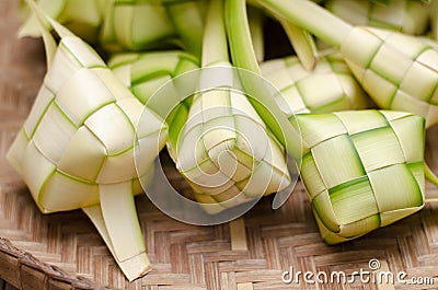 Ketupat casing and rice in bamboo container. Stock Photo