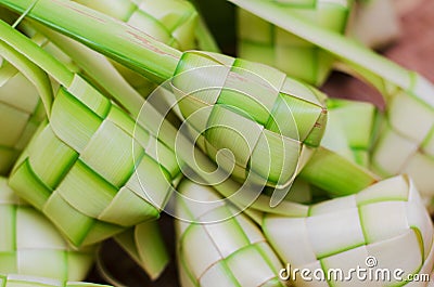 Ketupat casing and rice in bamboo container. Stock Photo