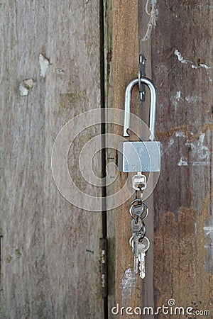 Key chain with three house or door keys on a dark wood table top. Stock Photo