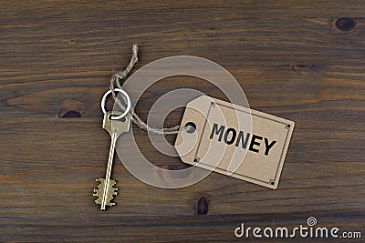 Key and a note on a wooden table with text - Money Stock Photo