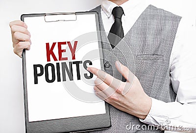 KEY POINTS inscription on a notebook in the hands of a businessman on a gray background, a man points with a finger to the text Stock Photo