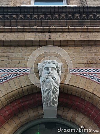 Key stone bust in arched brick doorway Stock Photo