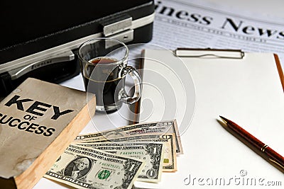 Key of success with notbook , briefcase , dollas and coffee. Stock Photo
