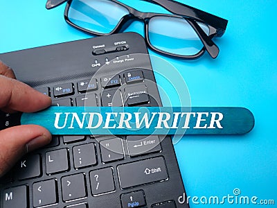 Keyboard and glasses with the word UNDERWRITER Stock Photo