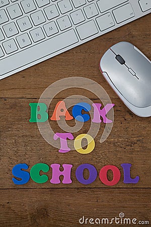 Keyboard, mouse and block letter with back to work text on wooden background Stock Photo