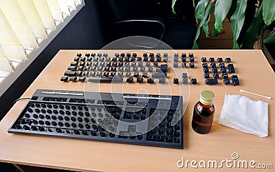 Keyboard on the table disassembled for complete cleaning and the keys neatly arranged in the right order Stock Photo