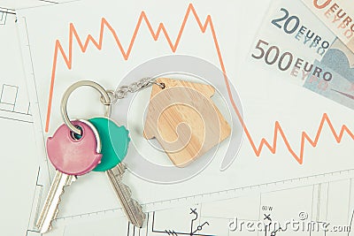 Keys, euro and downward graphs representing crisis of real estate market. Reduced housing prices Stock Photo