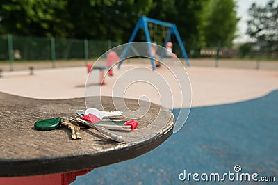 Keys forgotten on seat of spring rider at playground, space for text. Lost and found Stock Photo