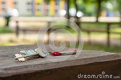 Keys forgotten on wooden bench outdoors, space for text. Lost and found Stock Photo