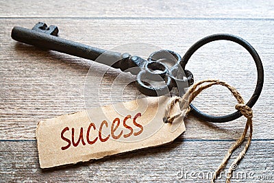 Keys to Success - Concept photo. Old key with paper label on wooden background - Success text. Stock Photo