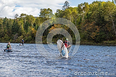 KHABAROVSK, RUSSIA - September 20, 2019 : Water tourists paddle SUP Stand up paddle board on the mountain river Anyui Editorial Stock Photo