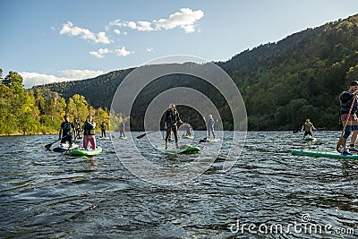 KHABAROVSK, RUSSIA - September 20, 2019 : Water tourists paddle SUP Stand up paddle board on the mountain river Anyui Editorial Stock Photo