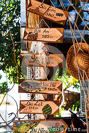 Khanh Hoa, Vietnam - 4 March 2023: many wooden signs with name of Vietnamese cities against summer hat in the market Editorial Stock Photo