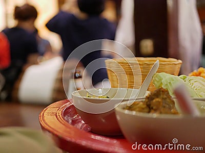 Khantok dinner, Northern Thai style meal which people sit and eat on a floor, with blurry background of people at a party Stock Photo
