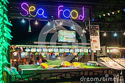 Khao Lak, Thailand, August 30, 2019: seafood neon restaurant sign and showcase with fresh fish on the street in a nightcap, Editorial Stock Photo