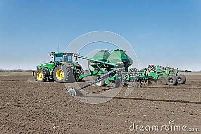 Tractor with trailed seeder on the field Editorial Stock Photo