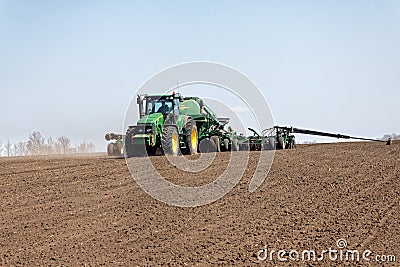 Tractor with trailed seeder on the field Editorial Stock Photo