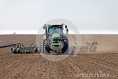 Tractor with trailed seeder on the field Editorial Stock Photo
