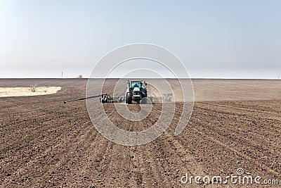 Tractor with trailed seeder on the field Editorial Stock Photo