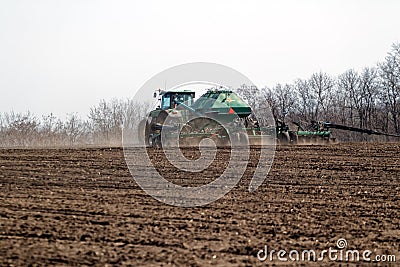 Tractor with trailed seeder on the field Editorial Stock Photo