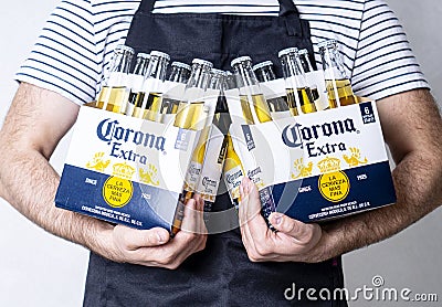 KHARKIV, UKRAINE - 16 April, 2021: Man holds two packs of Corona Beer. Editorial Stock Photo