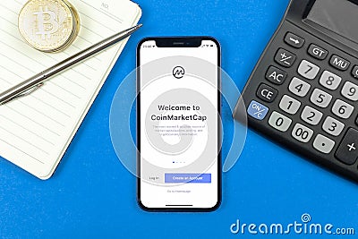 Kharkov, Ukraine - January 10, 2022: CoinMarketCap application logo, title screen. Business desktop background, top view Editorial Stock Photo