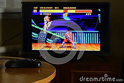 KHARKOV, UKRAINE - NOVEMBER 12, 2020: Sega mega drive video game controller on table with Street Fighter 2 game on display Editorial Stock Photo