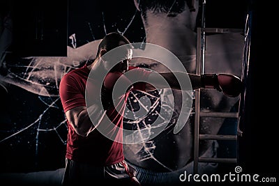 Kick boxer boxing as exercise for the big fight. Boxer hits punching bag. Young boxer trains on punching bag Stock Photo