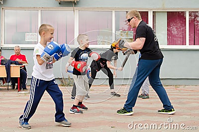 Kickboxing coach will practice punch with boy outdoor in summer Editorial Stock Photo