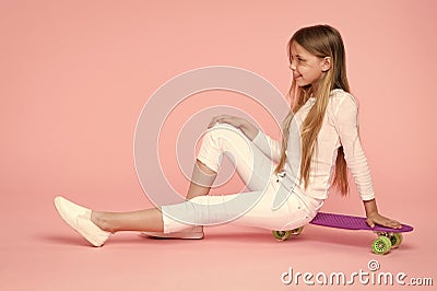 Kid adorable child long hair adore ride penny board. Ride penny board and do tricks. Girl likes to ride skateboard Stock Photo