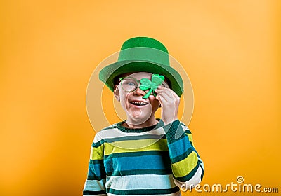 Kid on annual traditional St. Patrick's Day Parade on March in Ireland. Funny kid in star glasses, green leprechaun hat Stock Photo