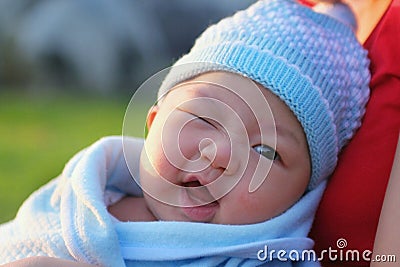 Kid baby with brown eyes on cute face smile and in blue hat on idyllic day. Stock Photo
