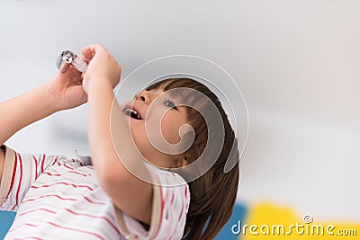 Kid blowing a noisemaker Stock Photo