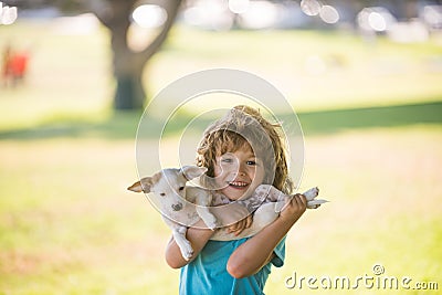 Kid boy with dog relaxing on nature. Lovely cute child embraces his pet doggy. Stock Photo
