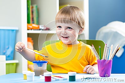 Kid boy painting at table in children room Stock Photo