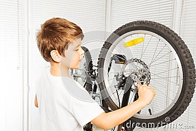 Kid boy repairing his bicycle at garage Stock Photo