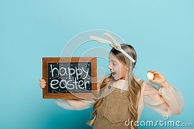 Kid with bunny ears holding chalkboard Stock Photo