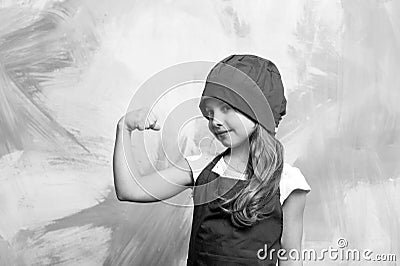 Kid cook flexing hand on colorful wall Stock Photo